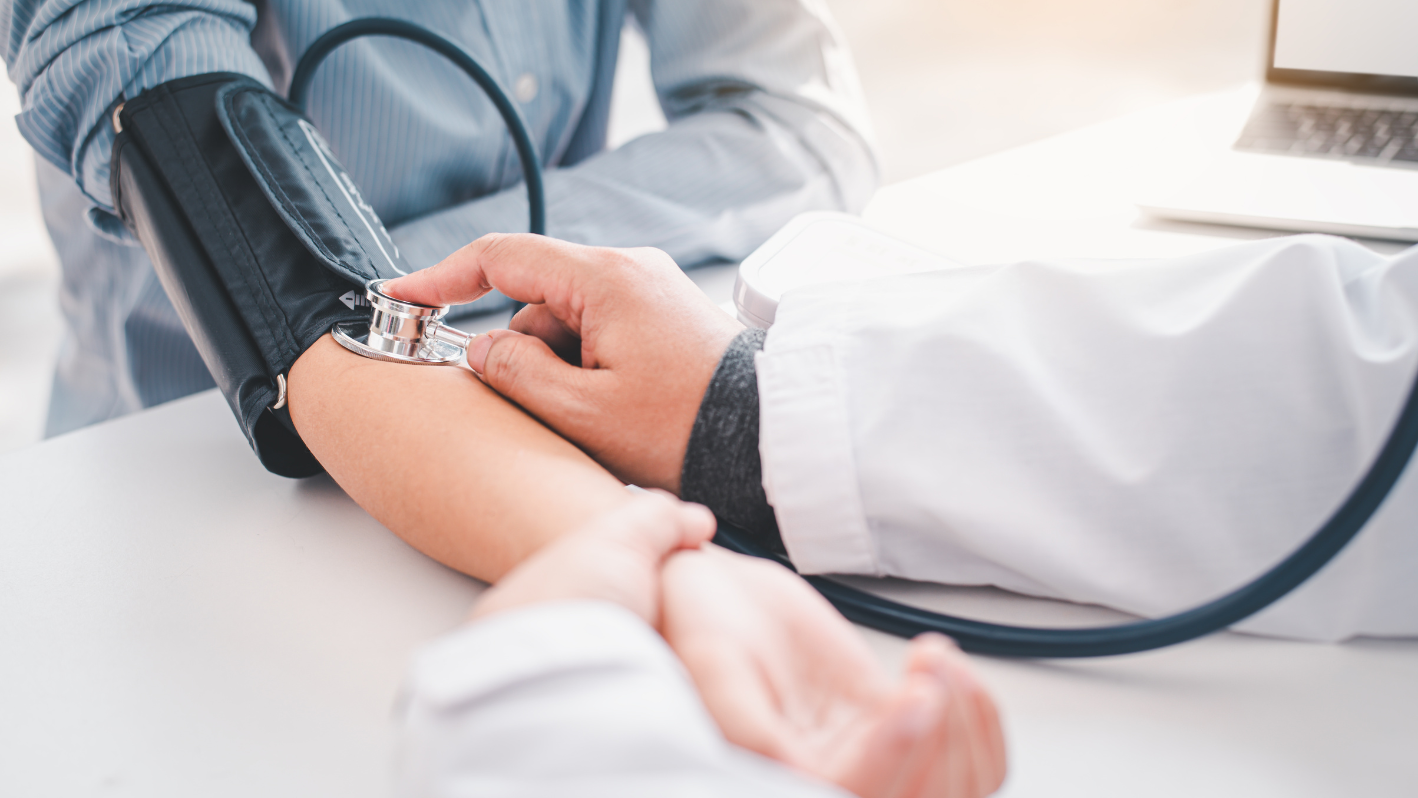 A doctor checking a patient's blood pressure with a stethoscope